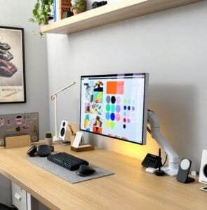 A computer monitor with a brand pallette sitting on a wood desk. Photo by Faizur Rehman on Unsplash