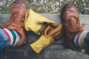 A pair of yellow work gloves next to someone with cute socks. Photo by Paulette Wooten on Unsplash